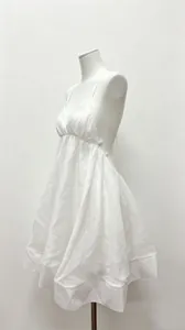 Side view of a white pleated deep V-neck backless babydoll dress on a white mannequin