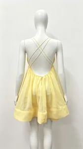 Detailed back view of a yellow backless pleated mini dress on a white mannequin