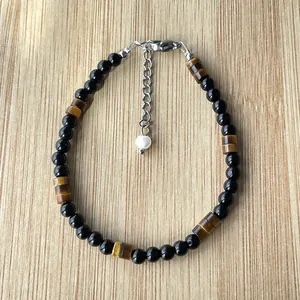 Détail du bracelet en perles d'œil de tigre et onyx noir avec fermoir en acier
