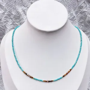 Vue détaillée d'un collier en perles de turquoise et d'œil de tigre avec accents dorés.