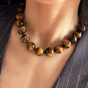 Vue détaillée d'un collier de perles en œil de tigre naturel porté par un modèle