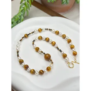 Gros plan d'un collier vintage en perles d'œil de tigre avec fermoir doré