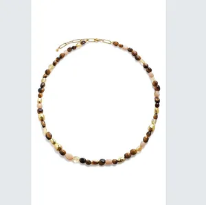 Vue détaillée d'un collier de perles en œil de tigre avec pierres naturelles et or.