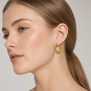 Model wearing a minimalist gold stainless steel hoop earring from the jewelry set collection