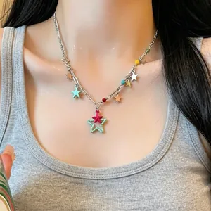 Close-up detail of a colorful lucky star metal clavicle necklace on a model's neck