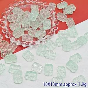 Detail view of 18x13mm rectangular pale green glass beads with floral relief