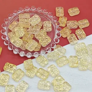 Close-up of rectangular golden liuli beads with floral pattern for DIY jewelry crafts
