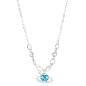 Detailed shot of a silver necklace with blue heart crystal and planet ring design.