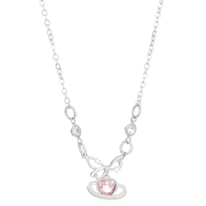 Close-up of silver planet heart necklace with pink zircon and crystal bow detail.