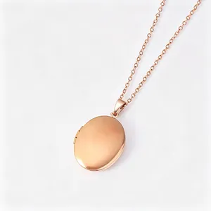 Vue détaillée d'un collier médaillon ovale en acier inoxydable or rose, fini lisse.