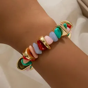 Vue détaillée d'un bracelet boho multicolore avec des perles en pierre et dorées