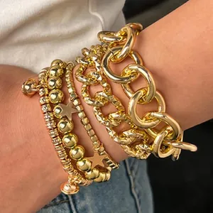 Vue macro d'un ensemble de bracelets dorés vintage multicouches à chaînes et perles