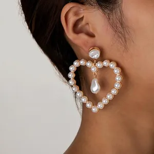 Vue macro détaillée d'une élégante boucle d'oreille pendante en perles en forme de cœur