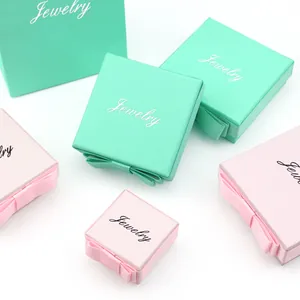 Eleganti scatole portagioie verde menta e rosa con fiocchi di nastro decorativi per regali