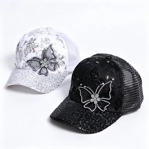 Detail view of rhinestone butterfly and sequined flower patterns on mesh baseball caps
