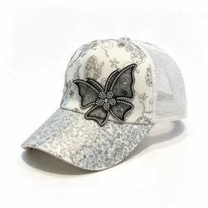 Close-up of silver sequin baseball cap with rhinestone butterfly design and mesh back