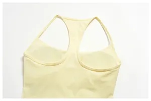 Detail view of yellow racerback yoga tank top showing nude-feel fabric texture.