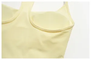 Close-up detail of the built-in chest pad and inner lining of a yellow yoga tank top