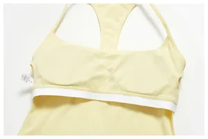 Detailed view of yellow racerback yoga sports bra with inner lining and care label