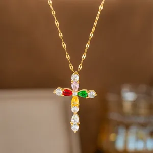 Nahaufnahme einer goldenen Kreuzhalskette mit lebhaften, bunten Zirkonsteinen.