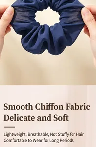Close-up of navy blue chiffon scrunchie being stretched for high elasticity