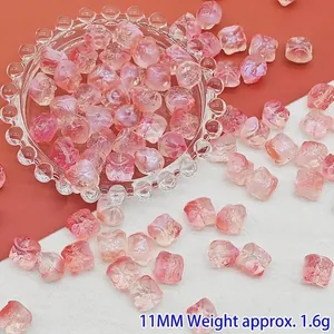 Nahaufnahme von 11 mm rosa und klaren glasierten Löwenperlen für DIY-Schmuckarbeiten.