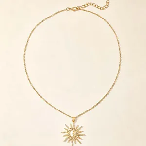 Detailed view of a gold-toned sun pendant necklace featuring crescent moon and star accents.