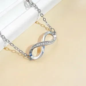 Macro detail of infinity symbol bracelet with sparkling crystal accents on silver chain