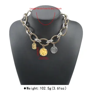 Macro detail view of chunky twisted cable chain necklace with vintage coin pendants