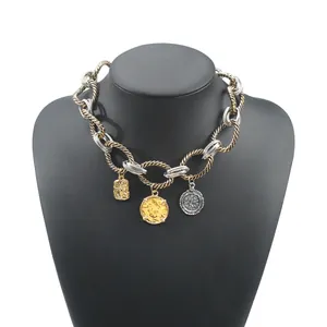 Macro view of two-tone chunky twisted chain necklace featuring unique coin pendants