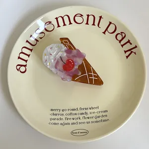 Détail d'une adorable pince à cheveux en acétate en forme de cornet de glace sur une assiette