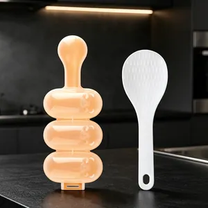 3-cavity sphere rice ball shaker mold and white paddle on a modern kitchen counter