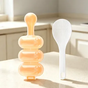 Close-up detail of three-cavity spherical rice ball shaker mold and white rice paddle