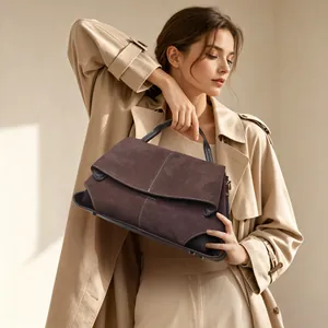 Chic brown suede handbag held by model, detailing the rich texture and commuter style.