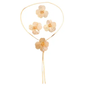 Detailed close-up of gold hollow flower jewelry set with intricate petal texture