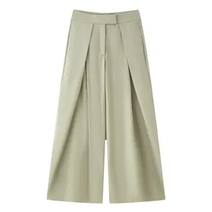 Detail shot of light olive wide-leg trousers featuring elegant front pleats.