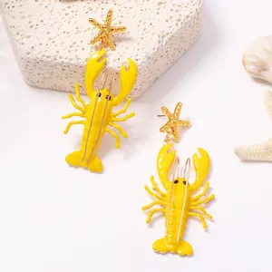 Detailansicht der leuchtend gelben Hummerohrringe mit goldenen Seesternen als Stecker