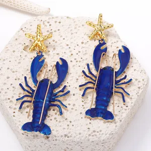 Detaillierte Makroaufnahme der blauen Emaille-Hummer-Ohrringe mit goldenen Seesternen