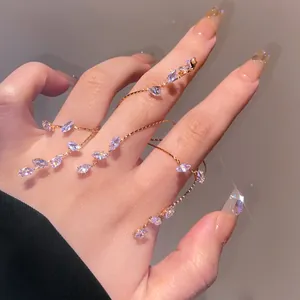 Vista dettagliata di un elegante bracciale a catena per dita in oro con foglie di zircone viola