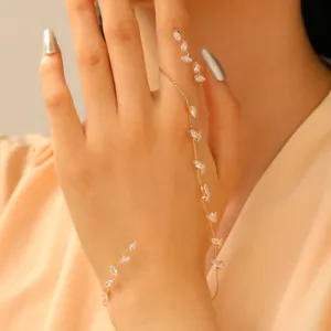 Dettaglio di elegante bracciale a catena da dito in oro con foglie di zircone