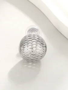 Detailed macro view of a silver hollow sphere clip-on earring with delicate mesh pattern