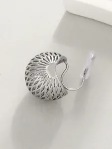 Close-up detail of silver hollow lattice clip-on earring with soft pad for non-pierced ears