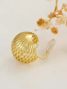 Macro detail of a golden hollow grid clip-on earring with soft silicone padding