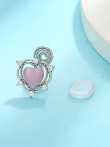 Close-up of silver-tone ear clip with pink heart stone and zircon accents