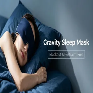 Primer plano de una mujer asiática con un antifaz para dormir con peso azul oscuro.
