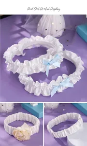 Detailed view of elegant bridal garter belts featuring blue bows and delicate flower accents