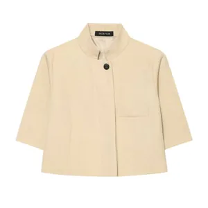 Detail view of a minimalist beige blazer featuring three-quarter sleeves and stand collar