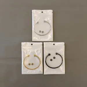 Detail view of silver gold and black stainless steel bangles in retail packaging
