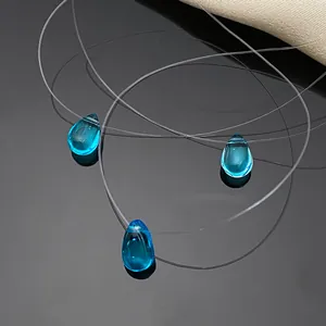 Close-up of three blue teardrop crystal pendants on invisible fishline string necklaces.