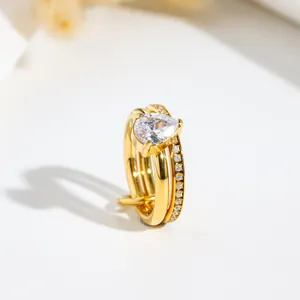 Macro detail of a golden double-layered ring with pear-shaped cubic zirconia stone.